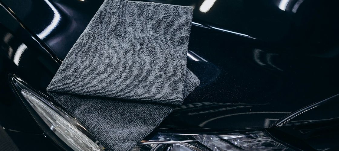 microfiber towel on a freshly detailed, mirror-gloss black hood