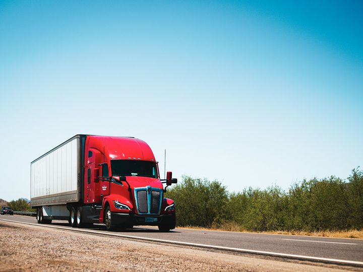 gleaming red semi truck and trailer on the highway
