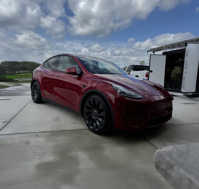 red Tesla detailed on-site in a customer's driveway